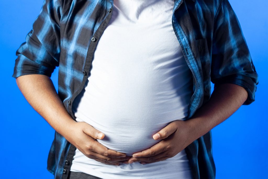 Indian young man showing his fat on the stomach