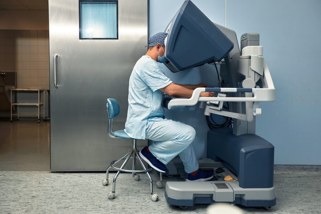 The surgeon is at the computer robot in a special control module, the medical robot is under the