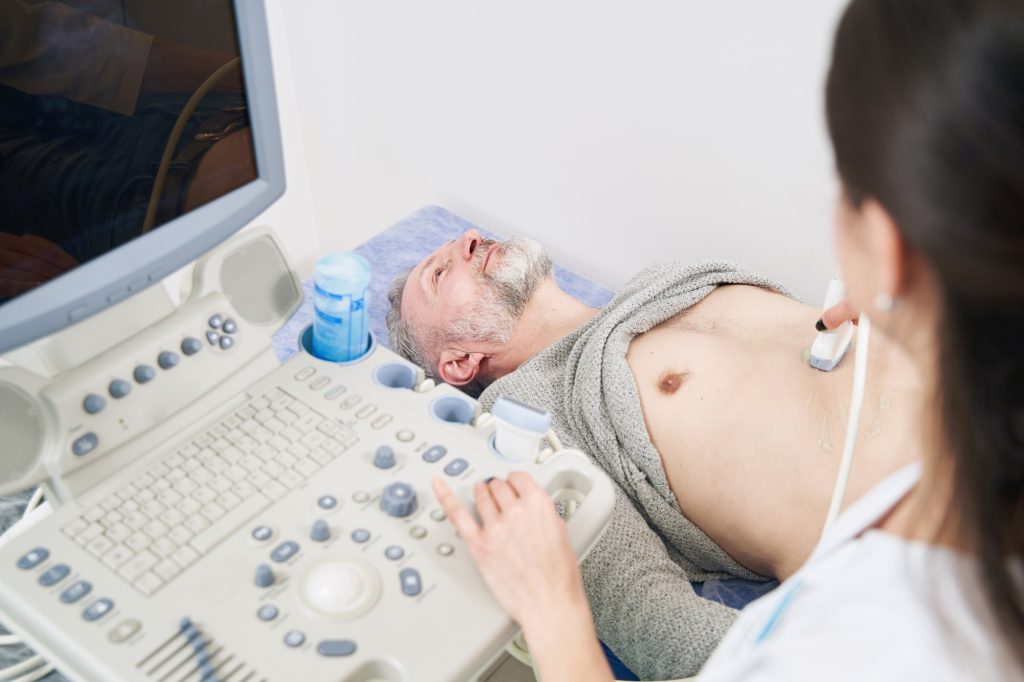 Tranquil mature male patient undergoing abdominal ultrasound